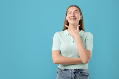 Photo of Smiling girl with braces on light blue background, space for text