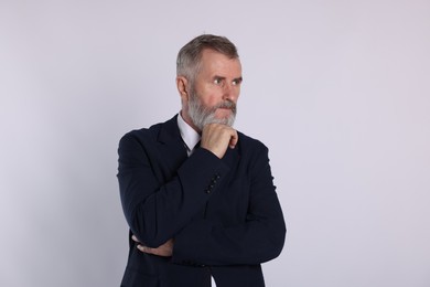 Portrait of senior man in suit on white background