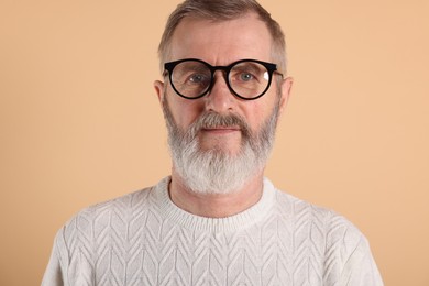 Photo of Portrait of senior man in glasses on beige background