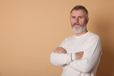 Portrait of senior man on beige background, space for text