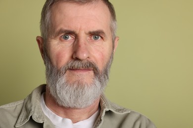 Portrait of senior man on green background