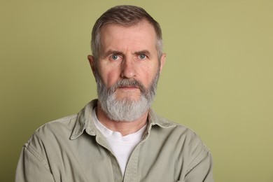 Portrait of senior man on green background