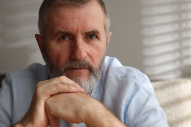 Portrait of handsome senior man at home