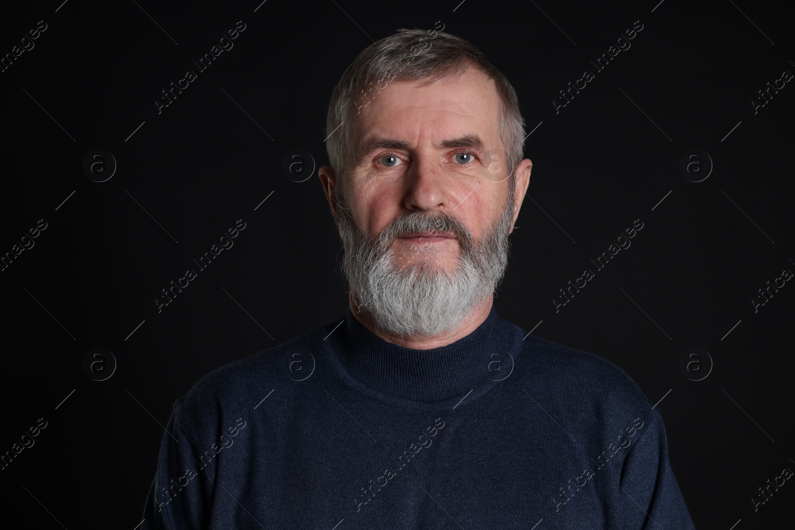 Photo of Portrait of senior man on black background