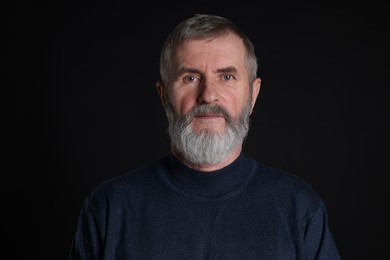 Photo of Portrait of senior man on black background