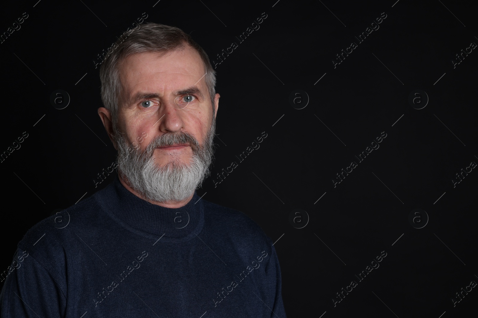 Photo of Portrait of senior man on black background, space for text