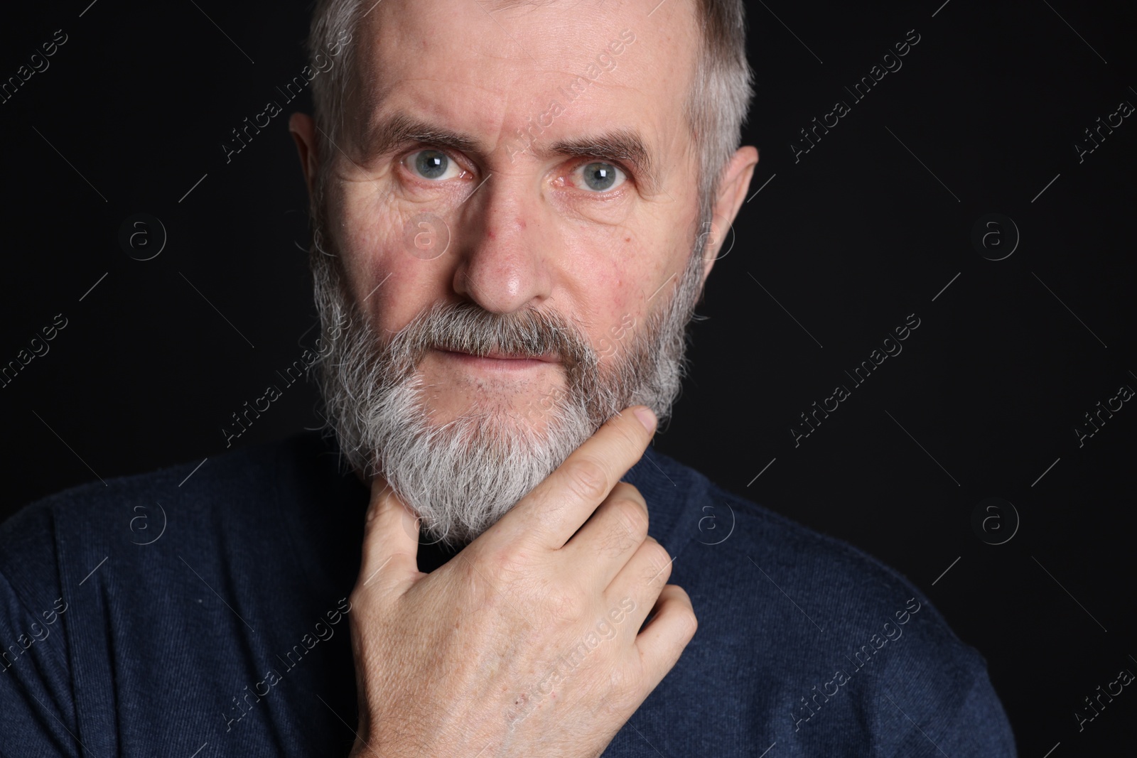 Photo of Portrait of senior man on black background