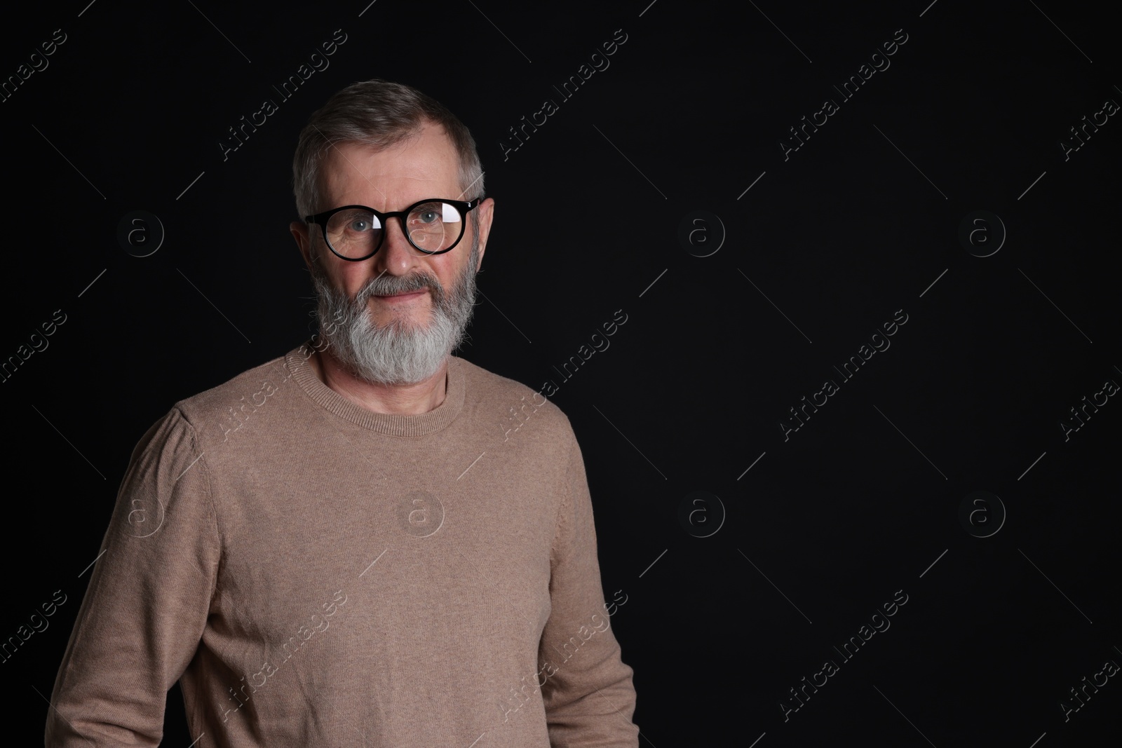 Photo of Senior man in glasses on black background, space for text