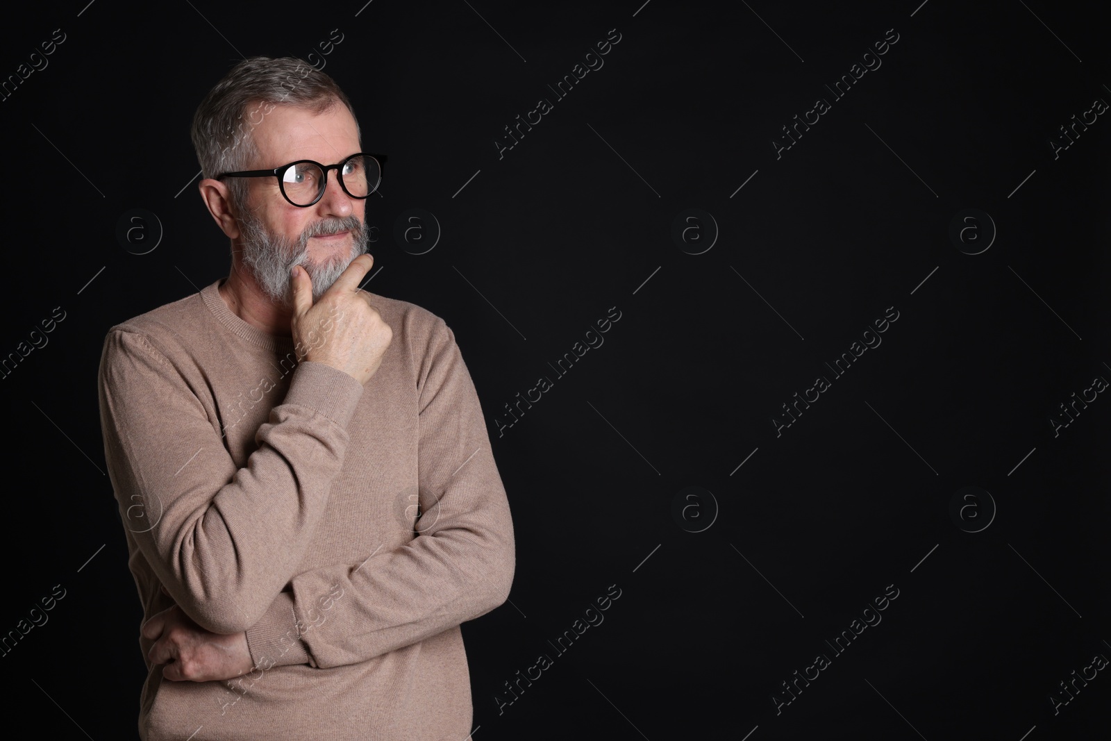 Photo of Senior man in glasses on black background, space for text