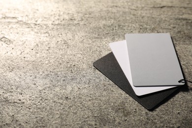 Photo of White balance calibration cards on grey background, closeup. Space for text