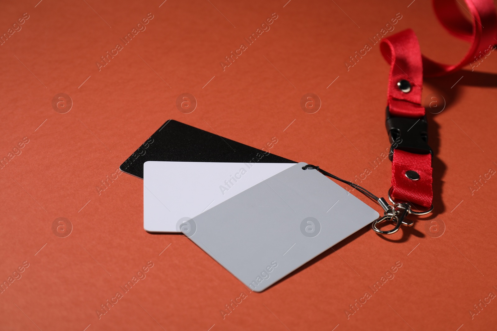 Photo of White balance calibration cards on red background, closeup