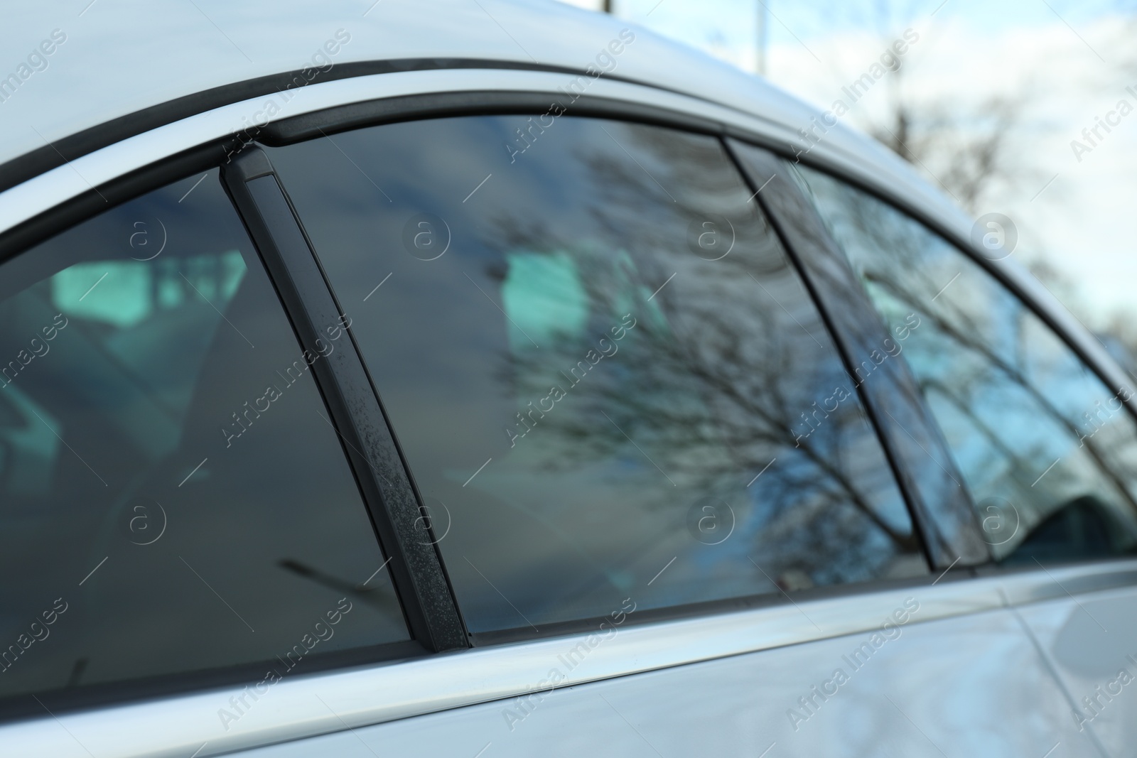 Photo of Modern car with tinting foil on window outdoors, closeup