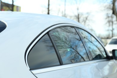 Photo of Modern car with tinting foil on window outdoors, closeup