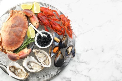 Photo of Many different sea food on white marble table, top view. Space for text