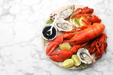 Photo of Many different sea food on white marble table, top view. Space for text