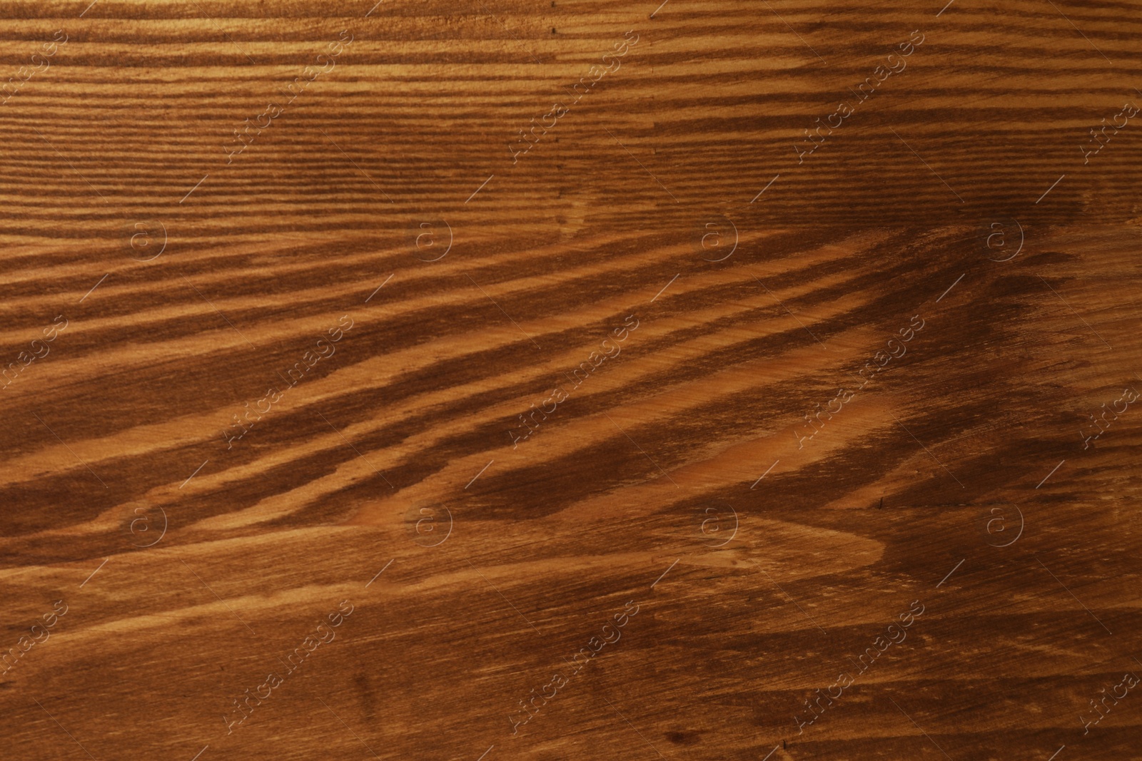 Photo of Applying walnut wood stain. Texture of wooden surface as background, top view