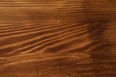 Photo of Applying walnut wood stain. Texture of wooden surface as background, top view