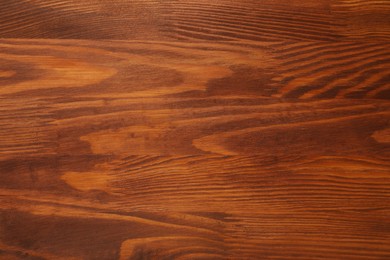 Photo of Applying walnut wood stain. Texture of wooden surface as background, top view