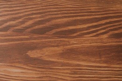 Photo of Applying walnut wood stain. Texture of wooden surface as background, top view