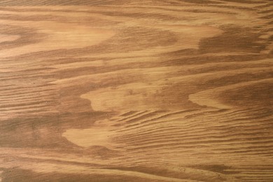 Photo of Applying walnut wood stain. Texture of wooden surface as background, top view