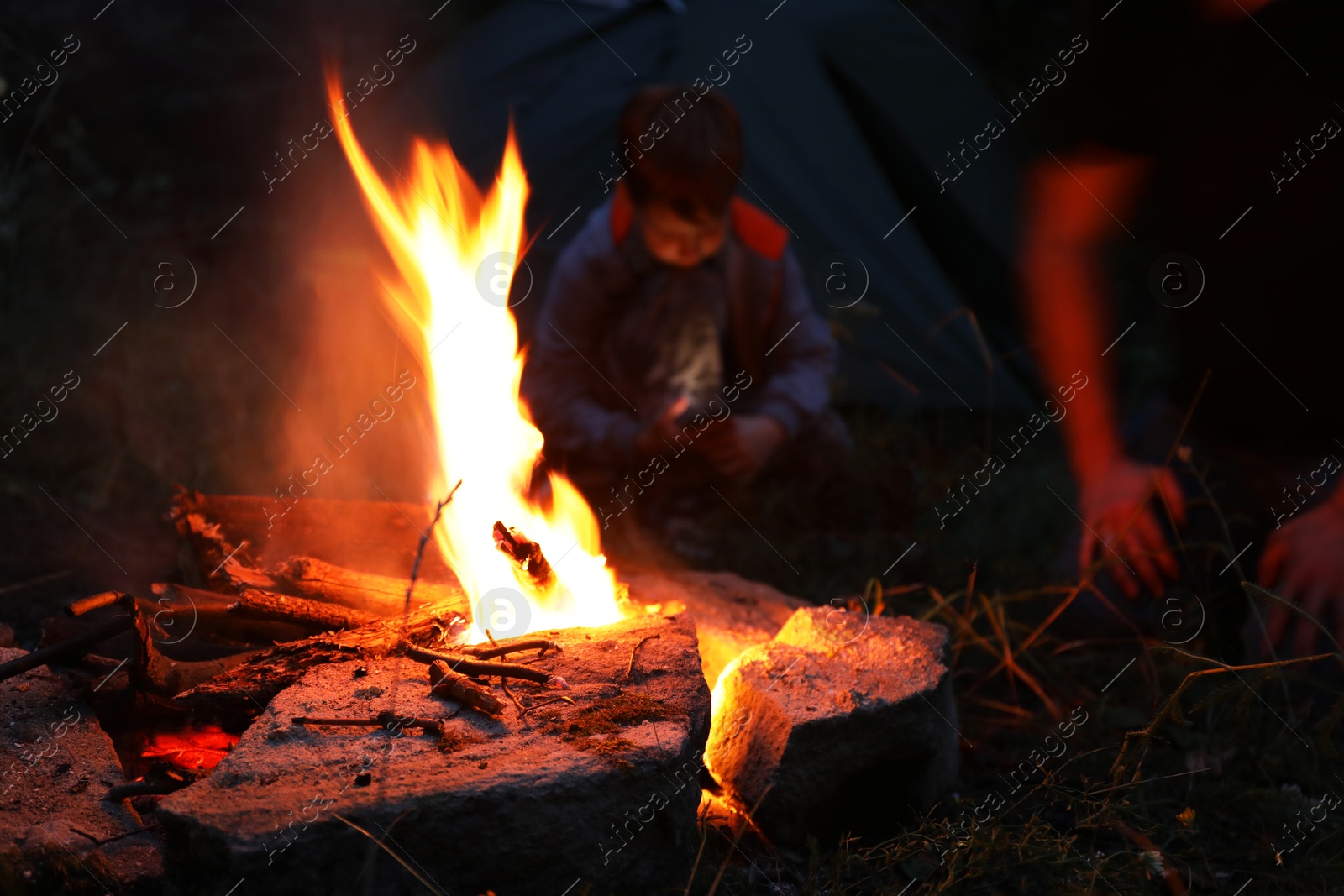 Photo of Man making bonfire in forest at night, closeup