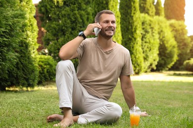 Man using smartphone on green lawn outdoors