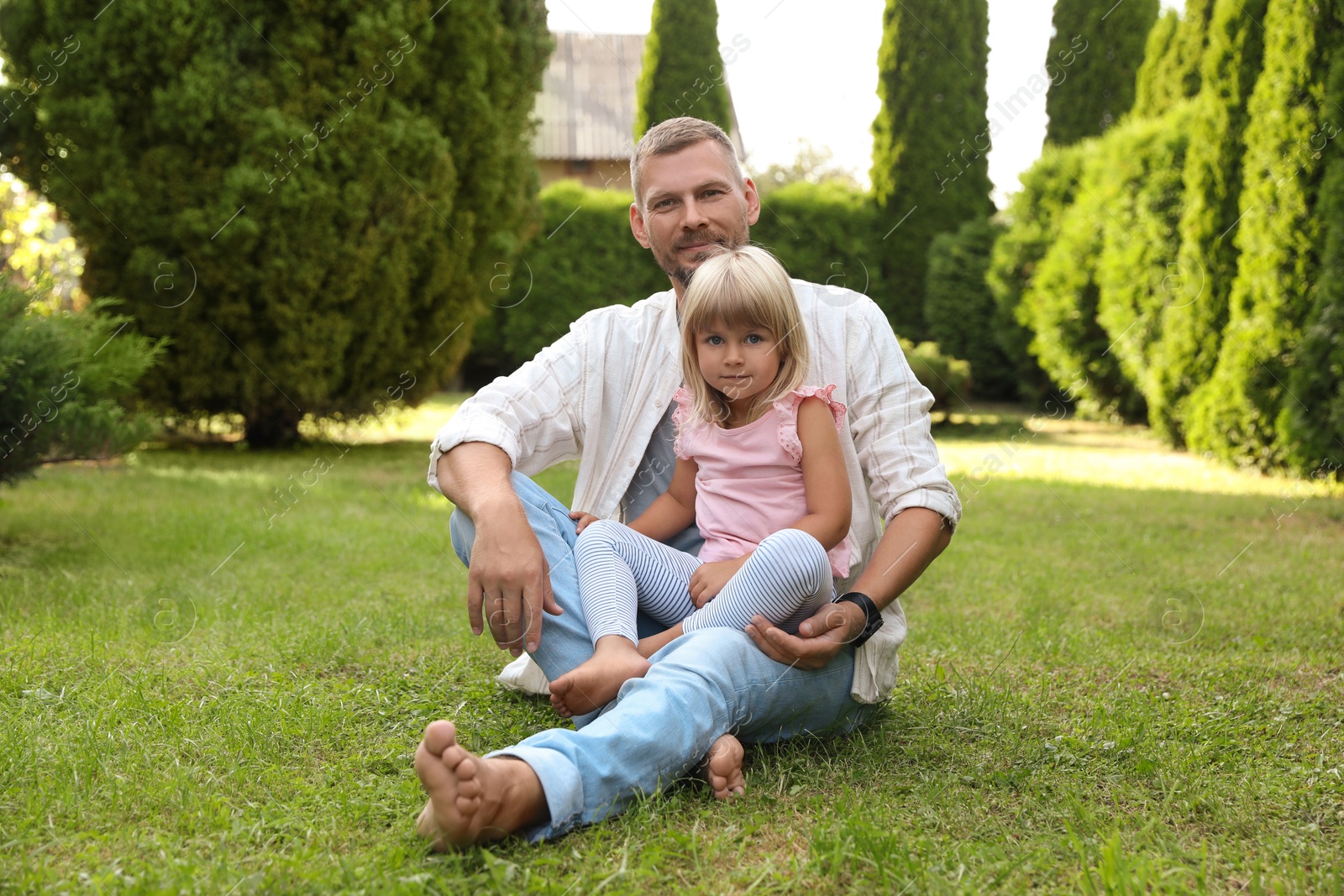 Photo of Father and his daughter spending time together on green lawn in park