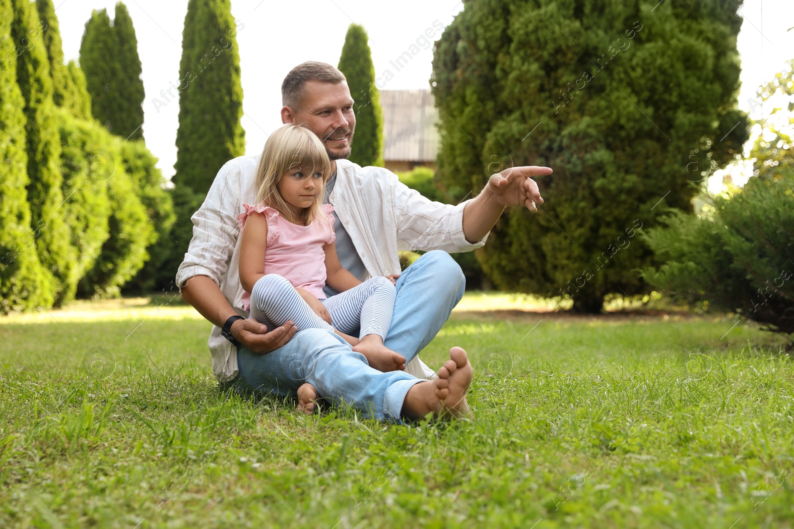 Photo of Father and his daughter spending time together on green lawn in park