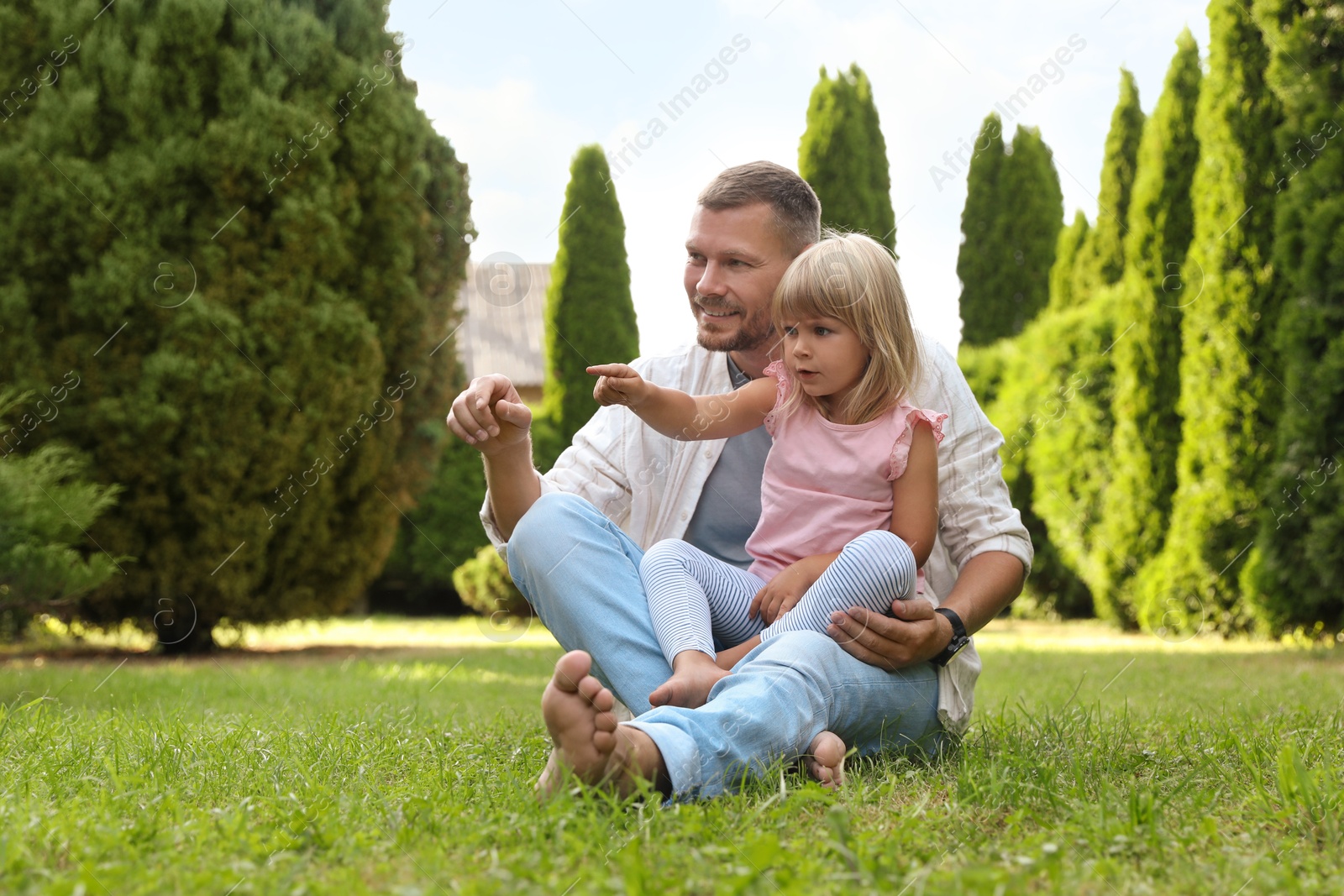 Photo of Father and his daughter spending time together on green lawn in park