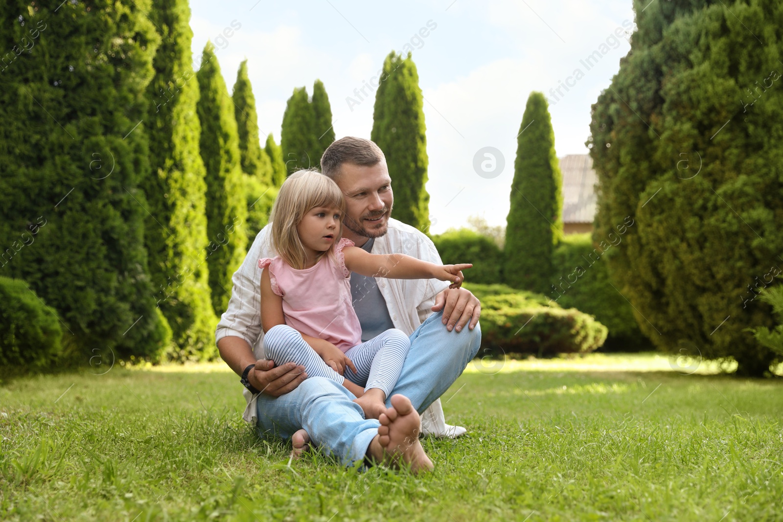 Photo of Father and his daughter spending time together on green lawn in park