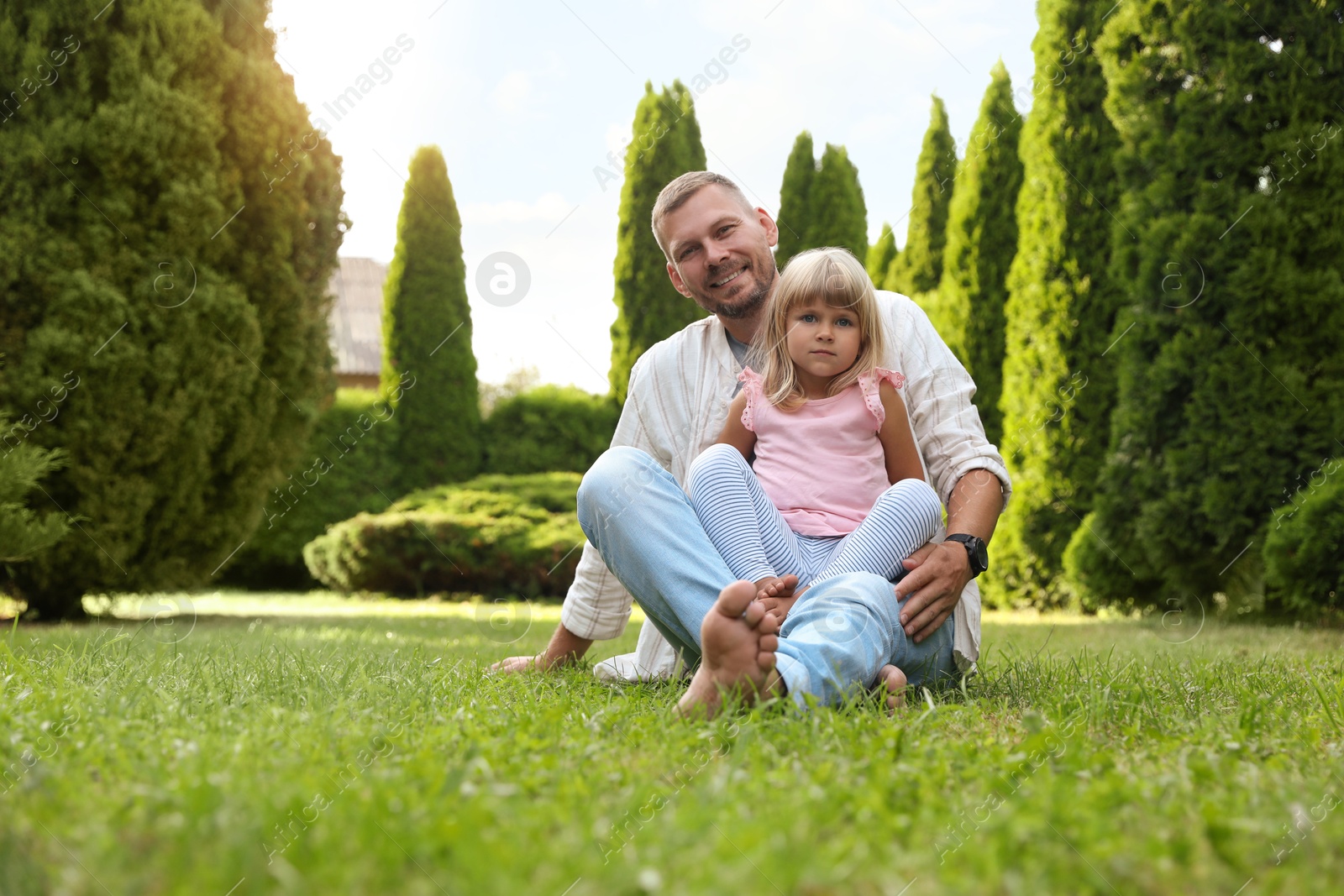 Photo of Father and his daughter spending time together on green lawn in park