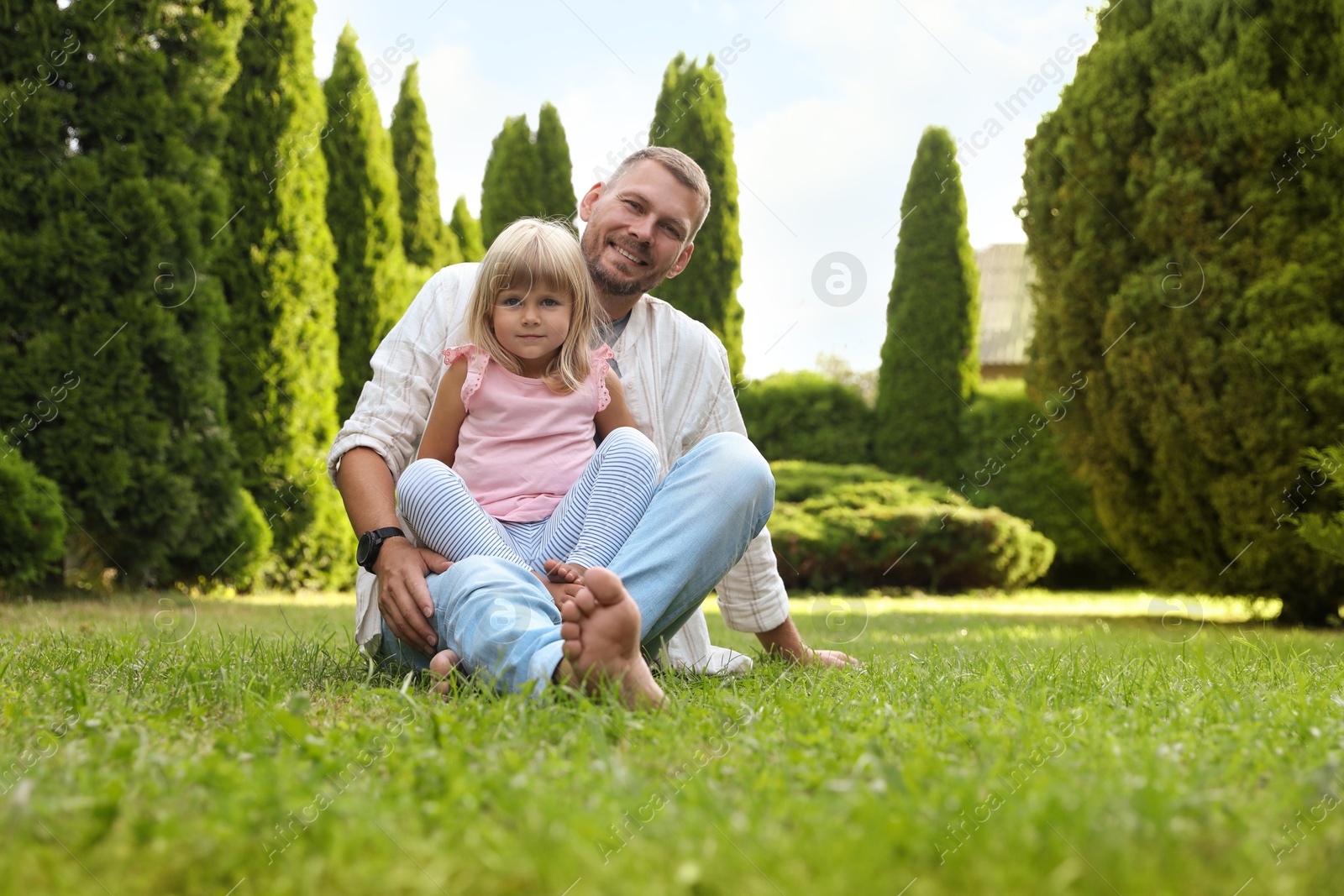 Photo of Father and his daughter spending time together on green lawn in park