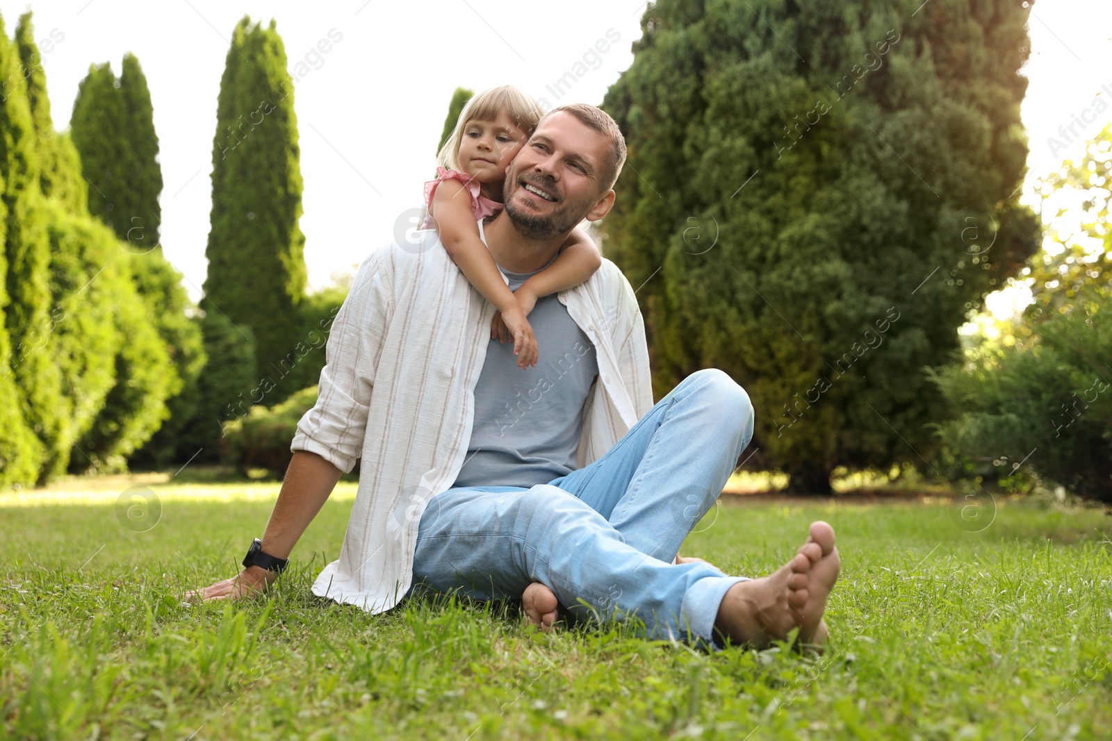 Photo of Father and his daughter spending time together on green lawn in park