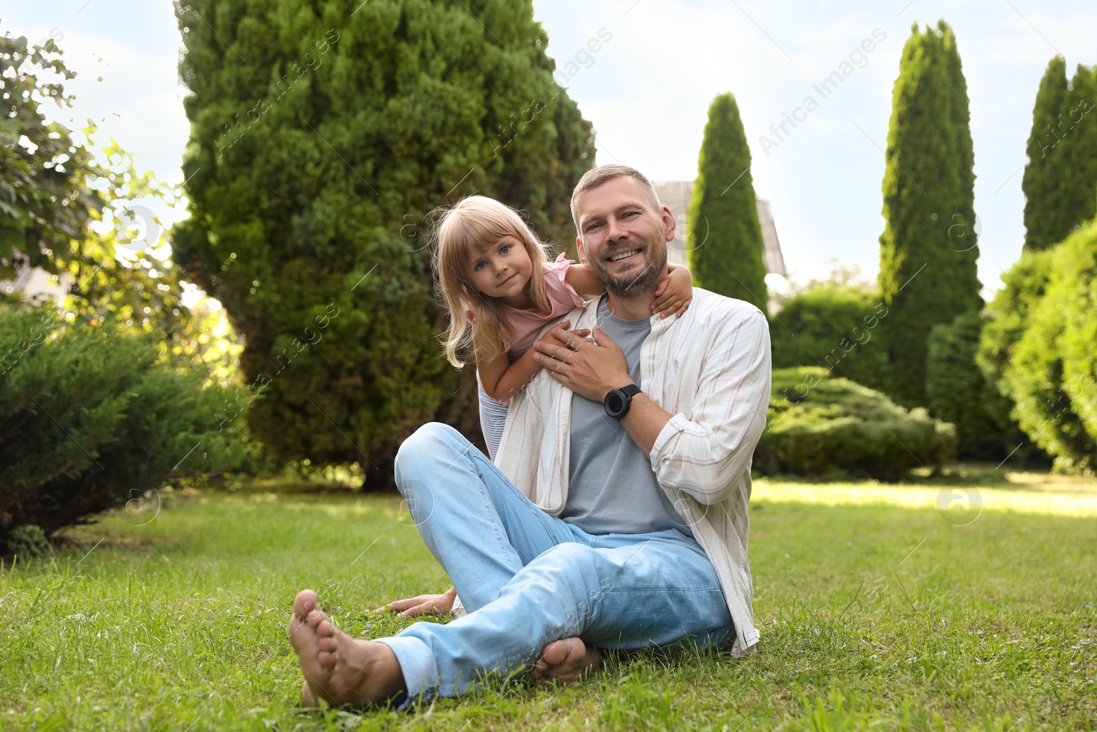 Photo of Father and his daughter spending time together on green lawn in park