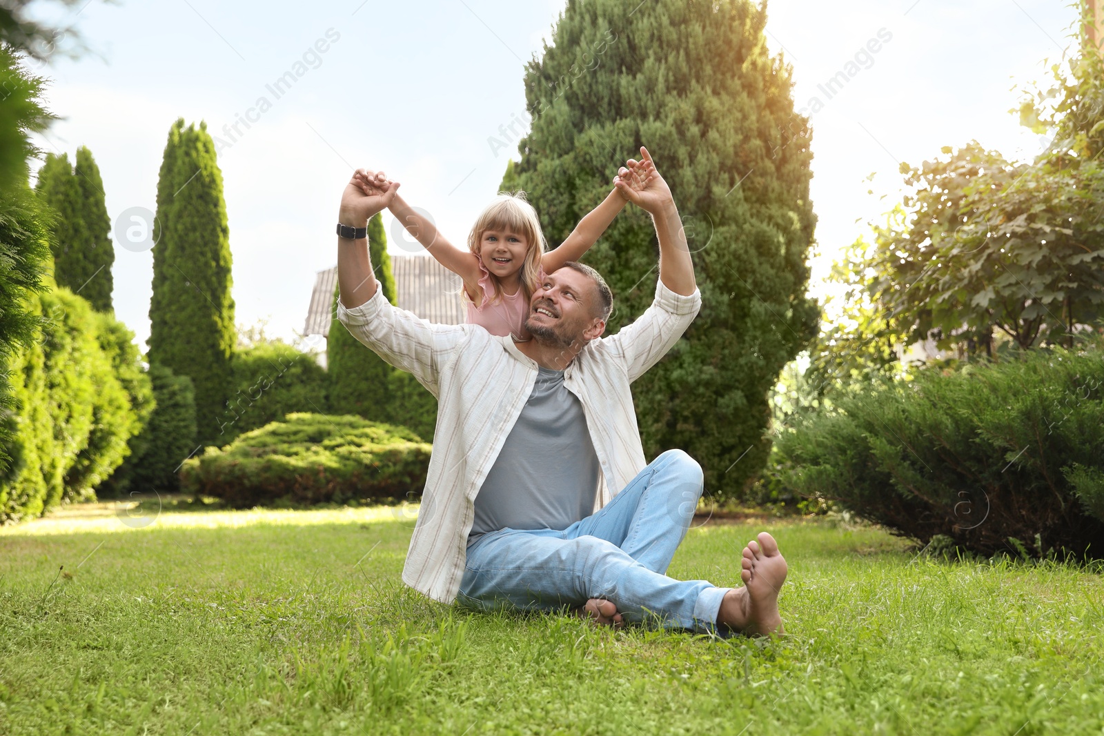 Photo of Father and his daughter spending time together on green lawn in park