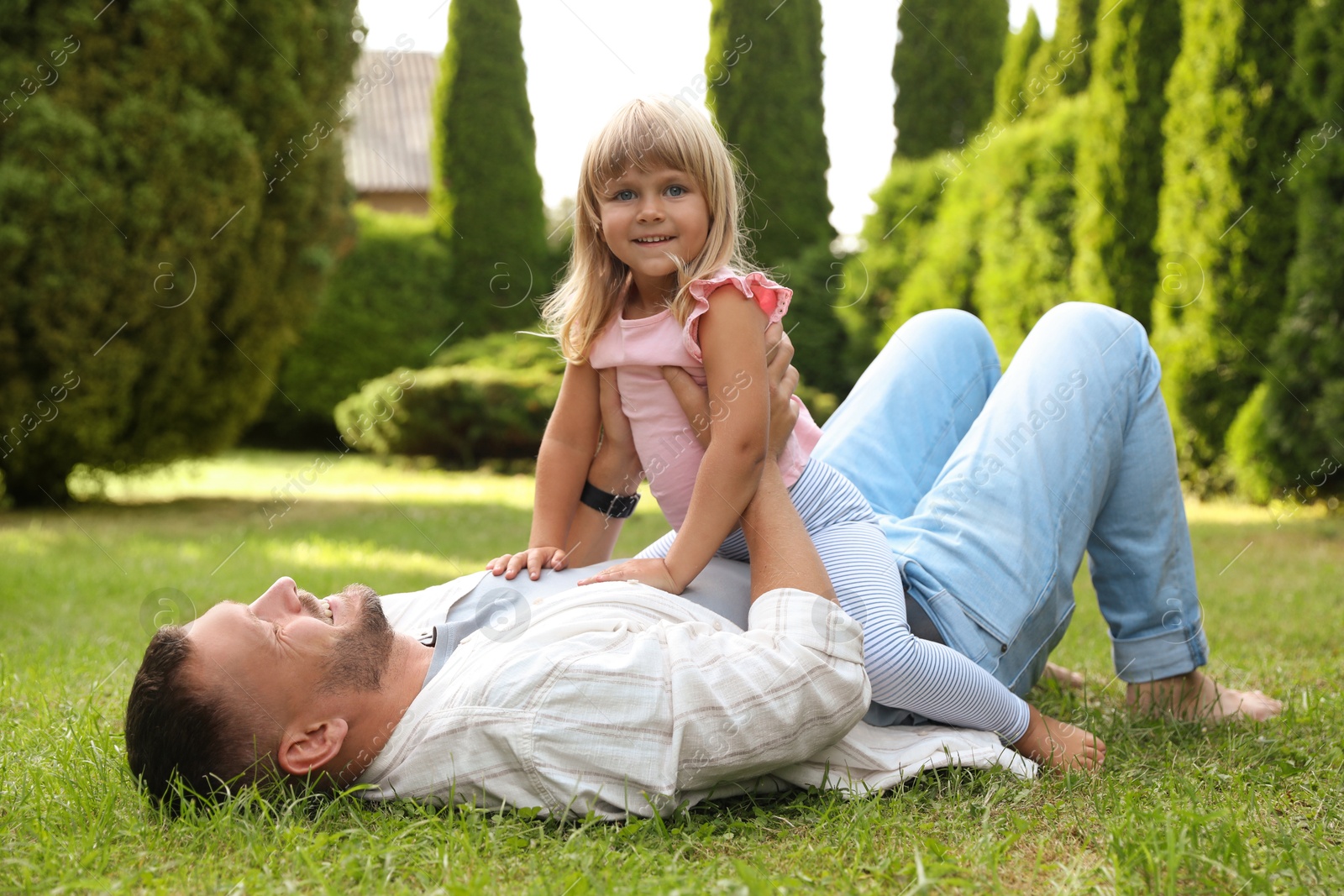 Photo of Father and his daughter spending time together on green lawn in park