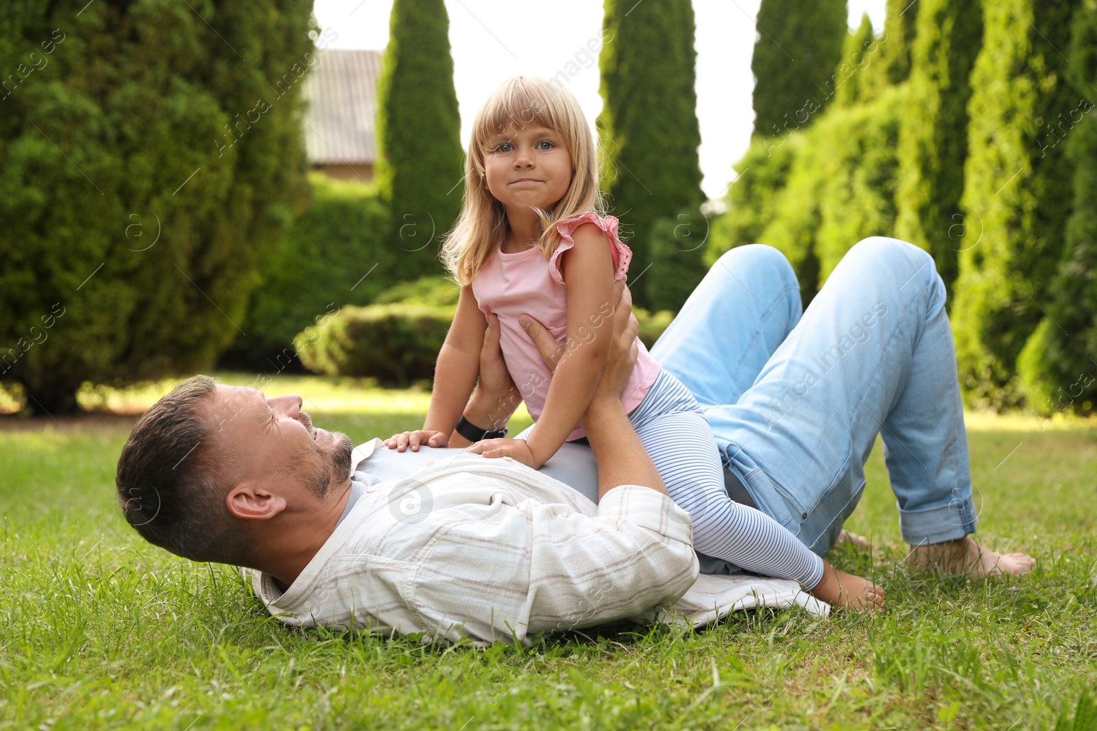 Photo of Father and his daughter spending time together on green lawn in park