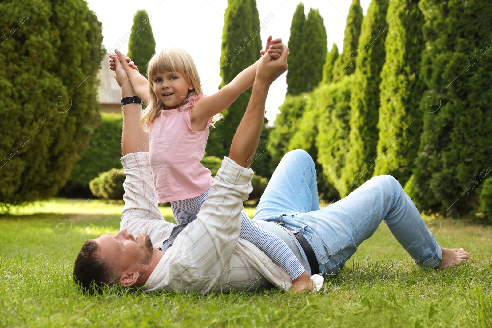 Photo of Father and his daughter spending time together on green lawn in park