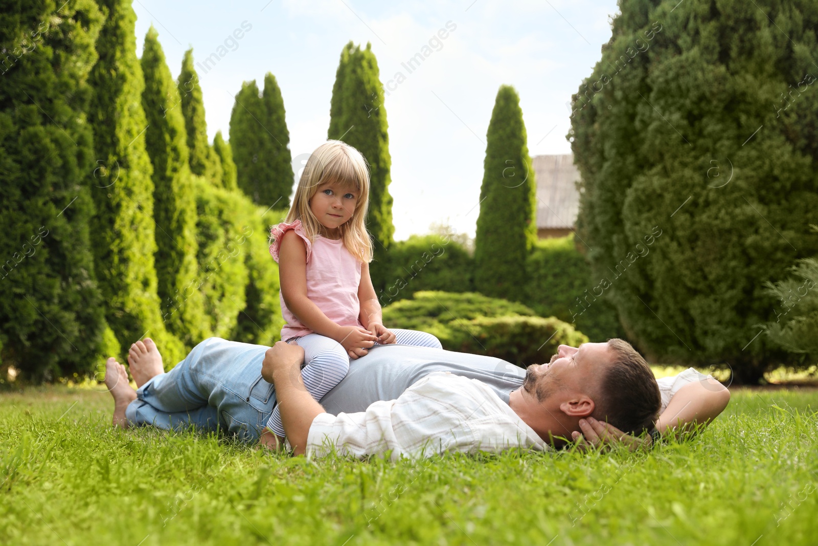 Photo of Father and his daughter spending time together on green lawn in park