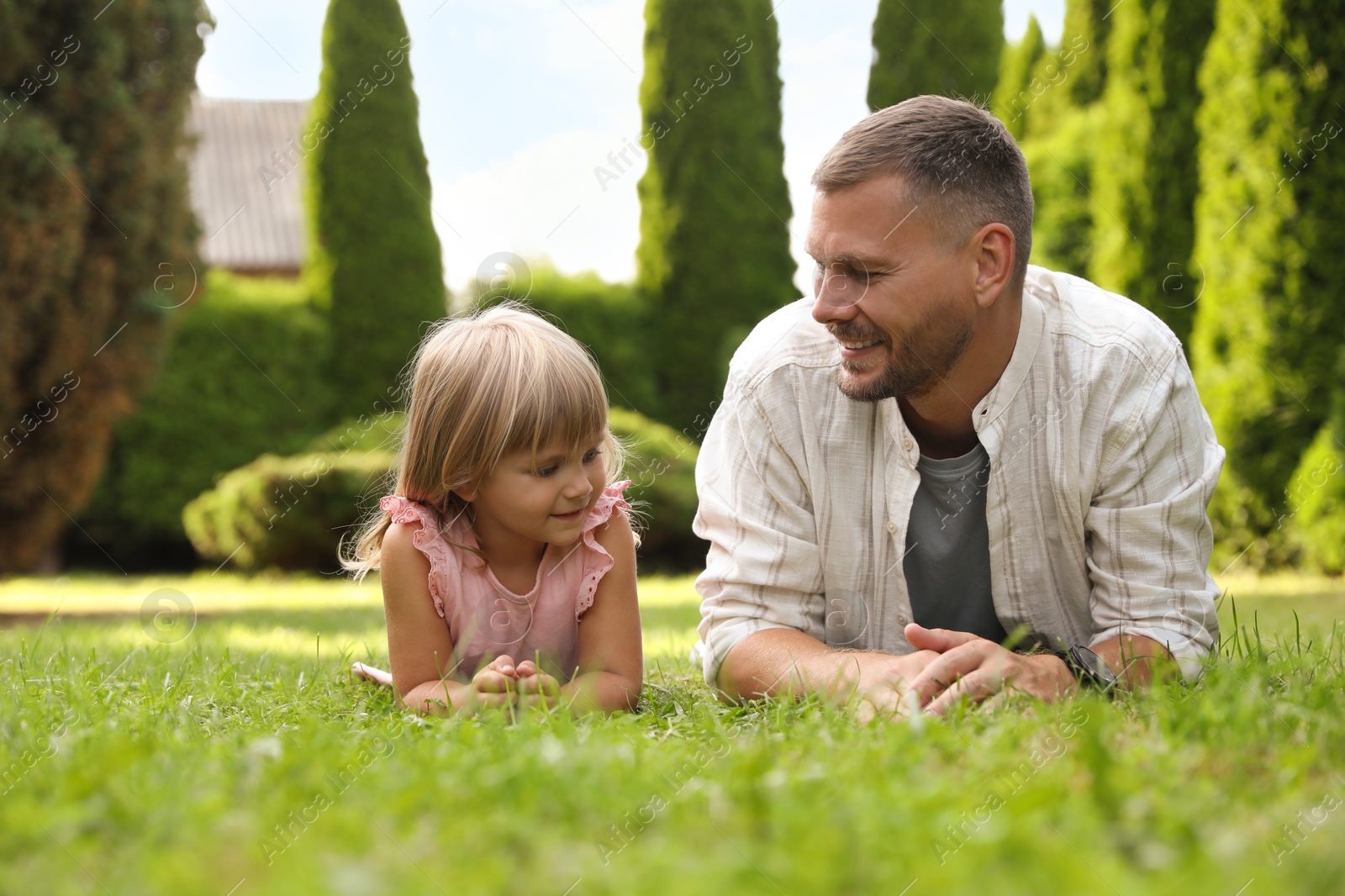 Photo of Father and his daughter spending time together on green lawn in park