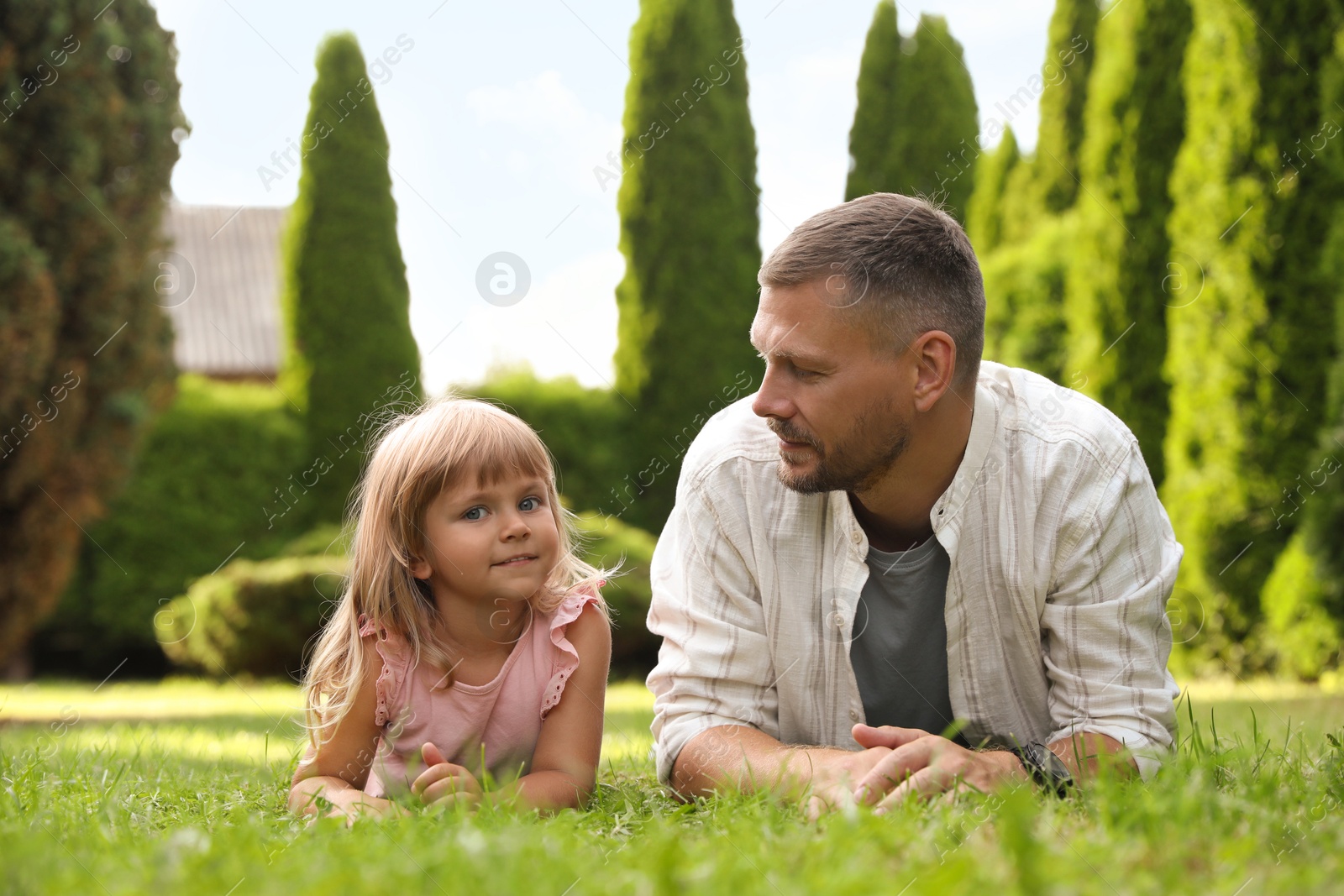 Photo of Father and his daughter spending time together on green lawn in park