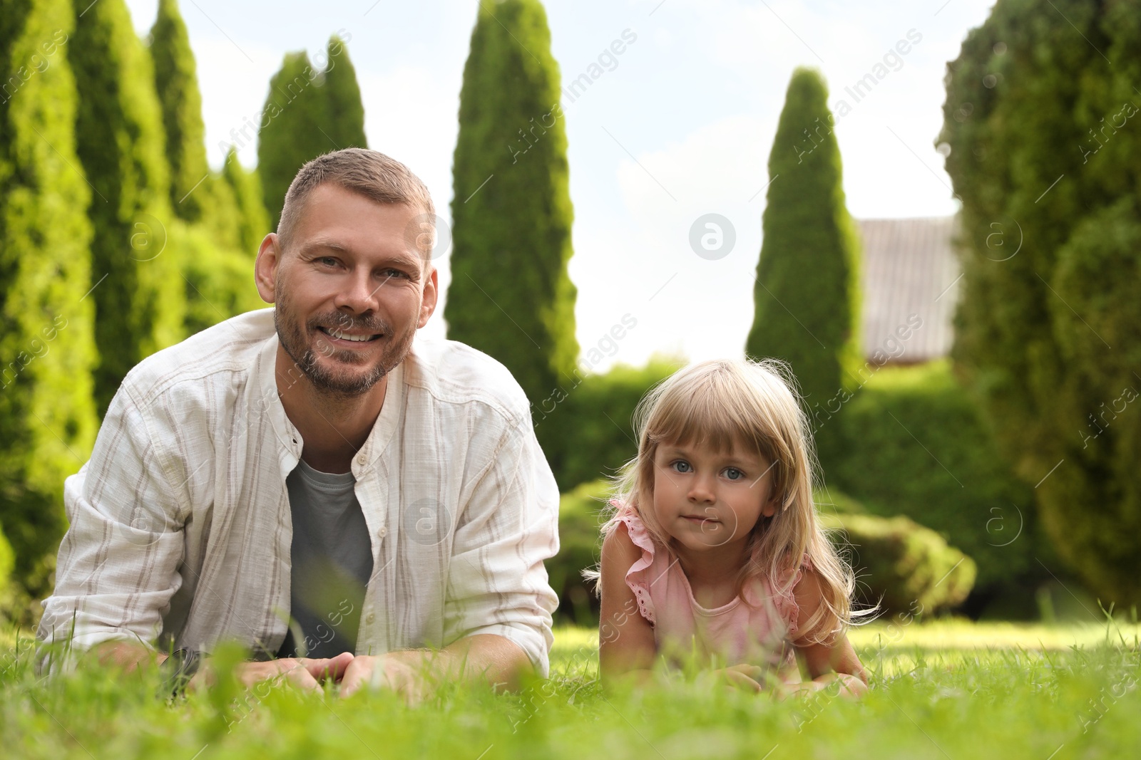 Photo of Father and his daughter spending time together on green lawn in park