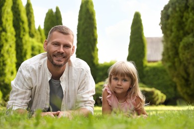 Photo of Father and his daughter spending time together on green lawn in park