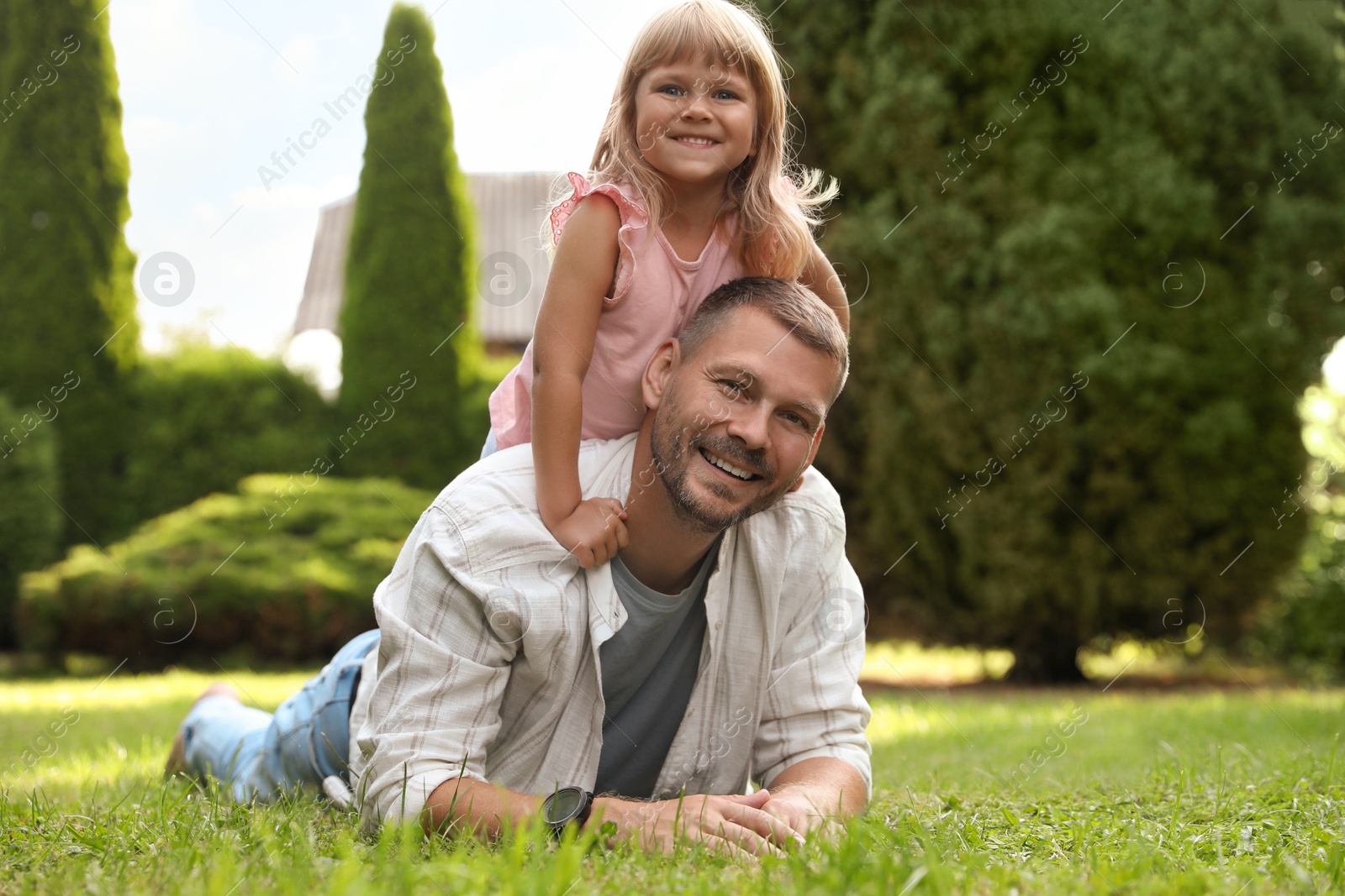 Photo of Father and his daughter spending time together on green lawn in park