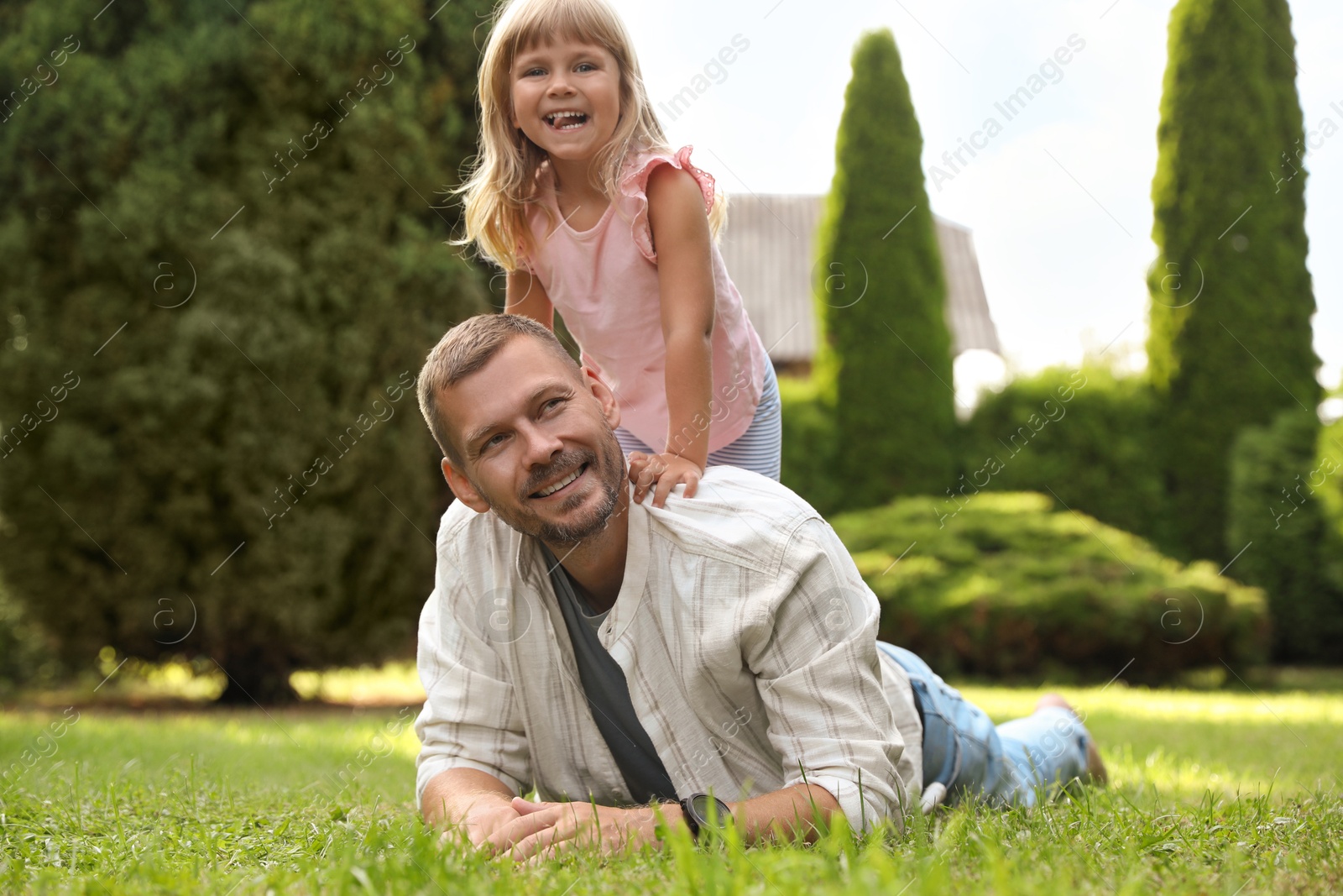 Photo of Father and his daughter spending time together on green lawn in park