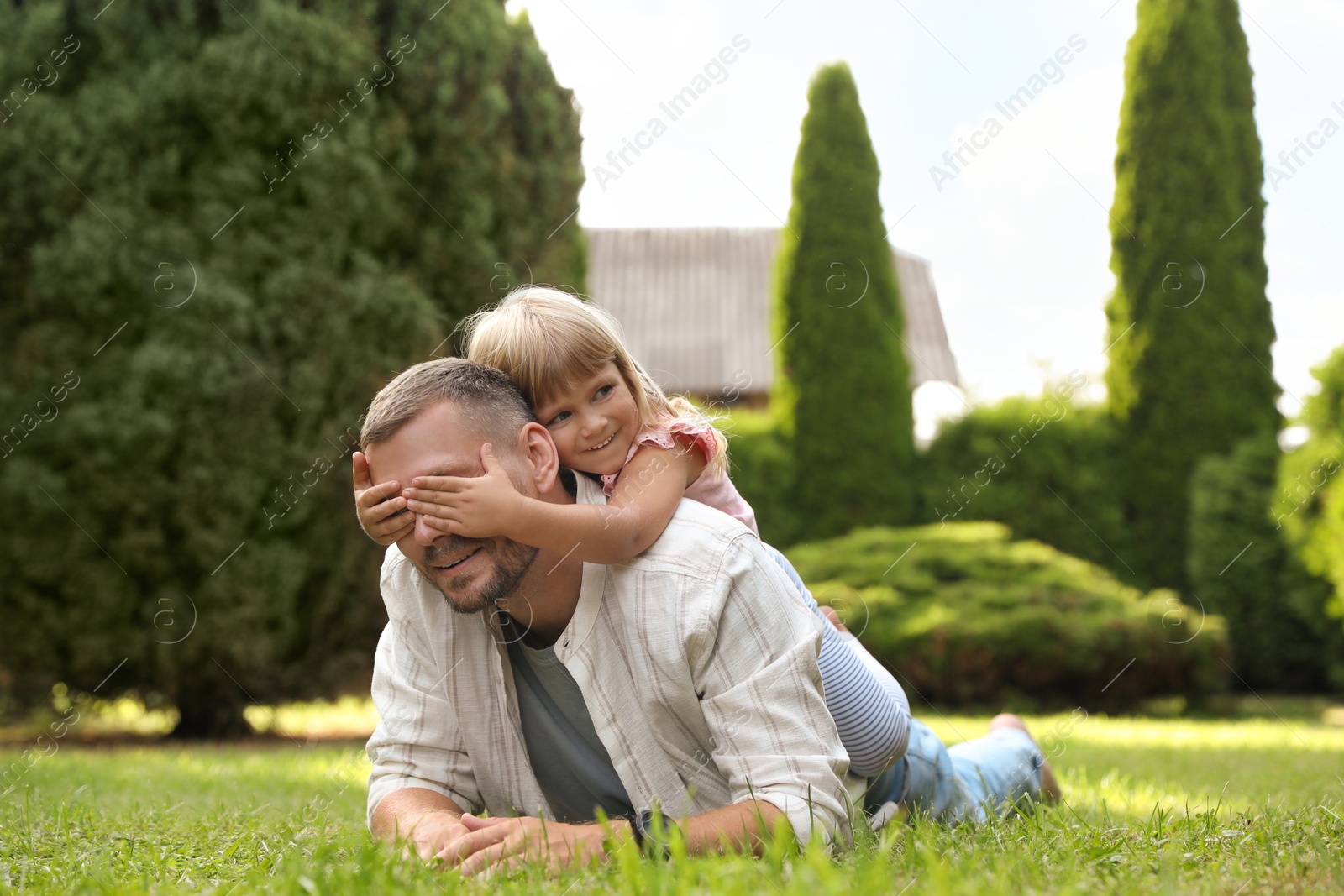 Photo of Father and his daughter spending time together on green lawn in park