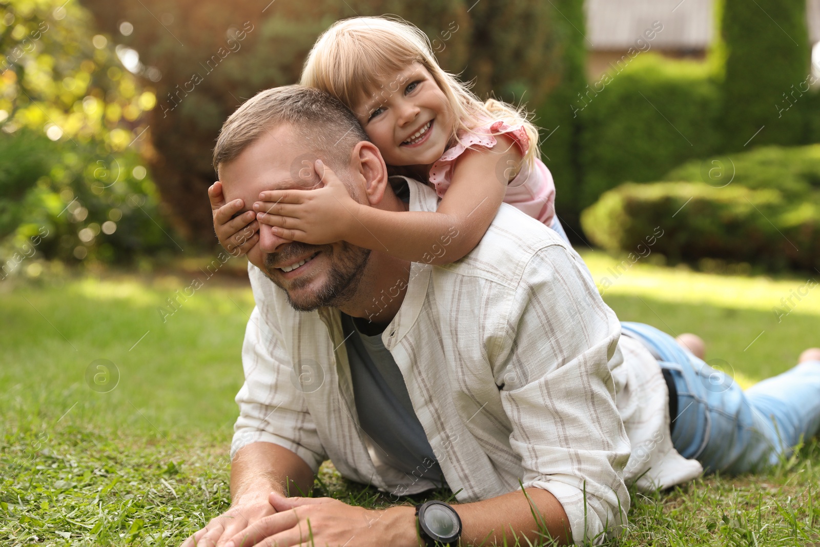 Photo of Father and his daughter spending time together on green lawn in park