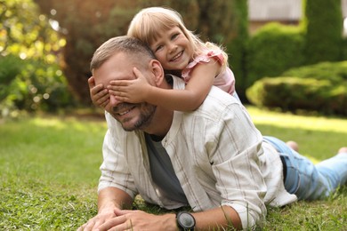 Photo of Father and his daughter spending time together on green lawn in park