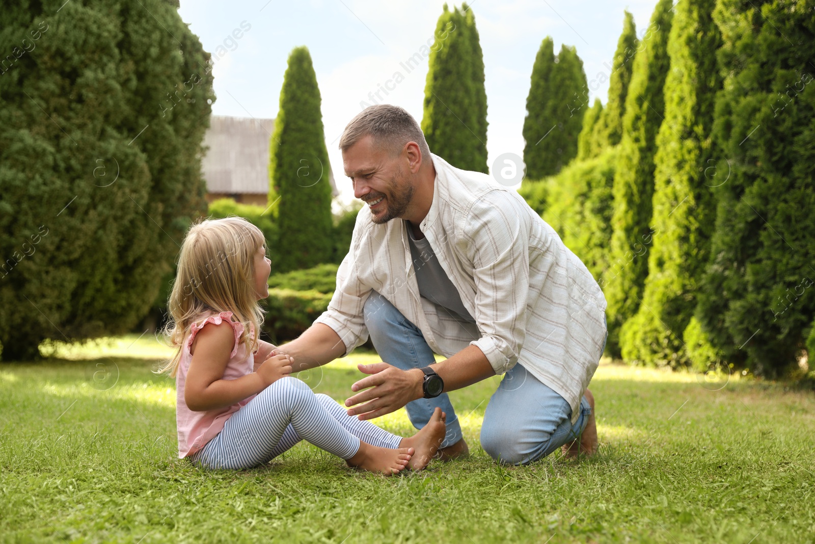 Photo of Father and his daughter spending time together on green lawn in park