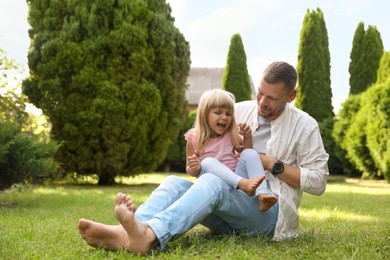 Photo of Father and his daughter spending time together on green lawn in park